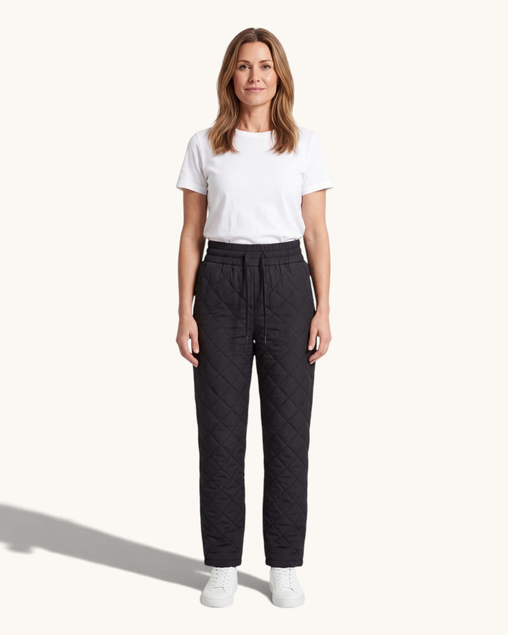 Svarta quiltade byxor med resårmidja, burna med vit t-shirt