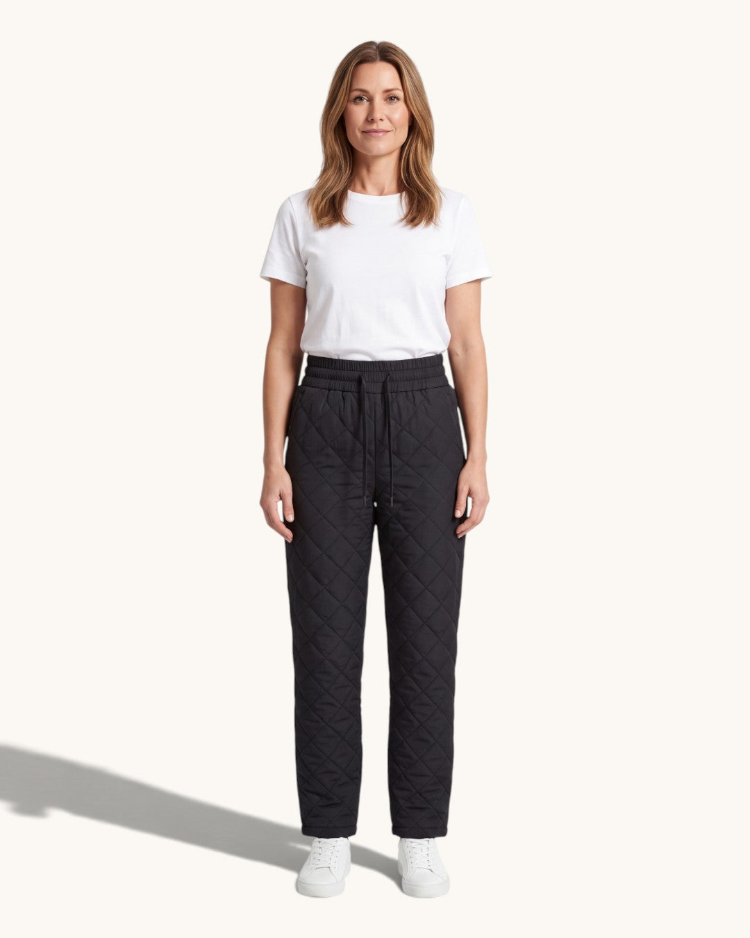 Svarta quiltade byxor med resårmidja, burna med vit t-shirt